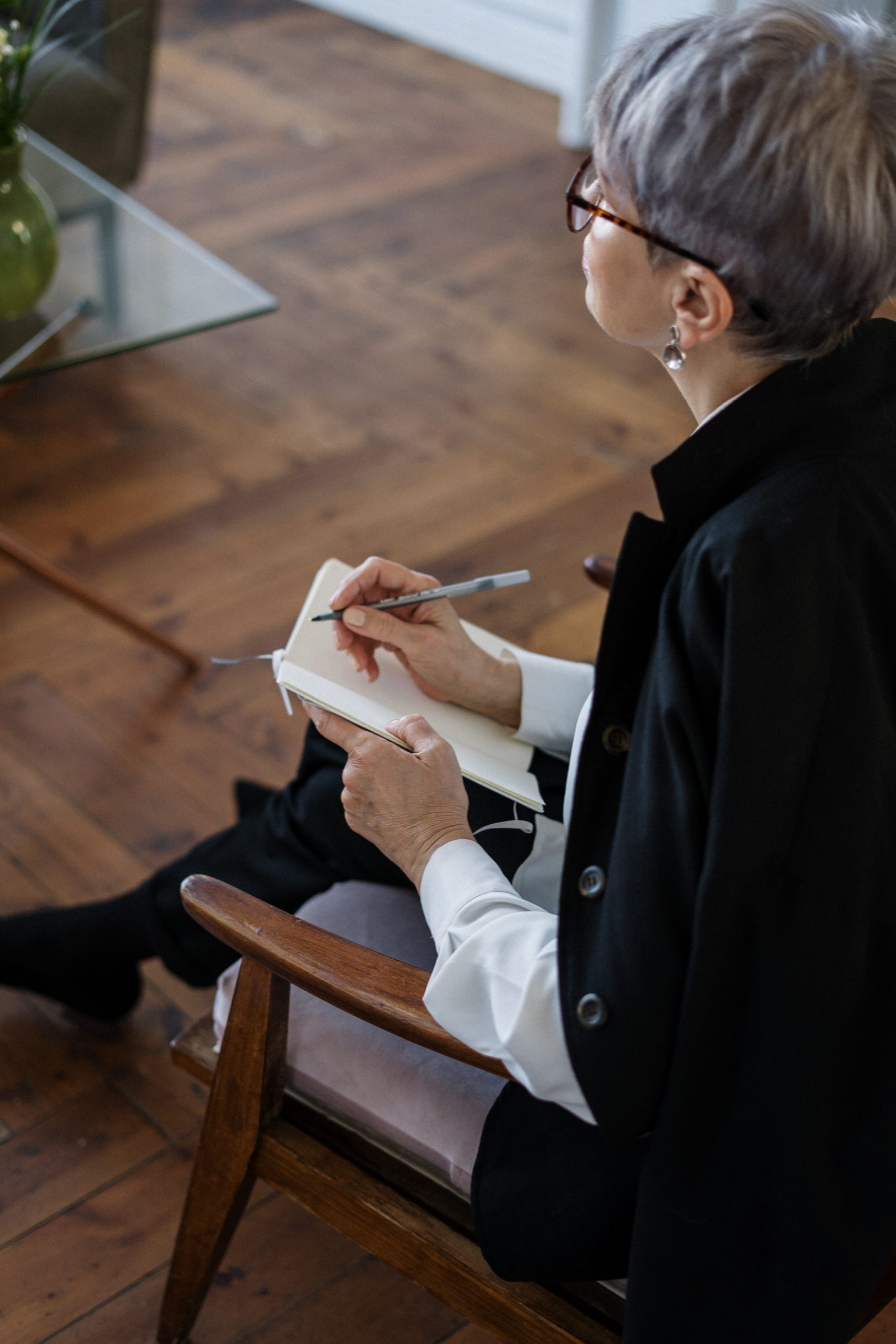 woman sitting and writing in notebook